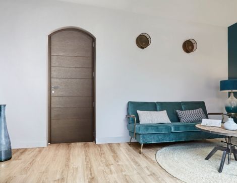 intérieur de maison avec une porte d'entrée marron cintrée