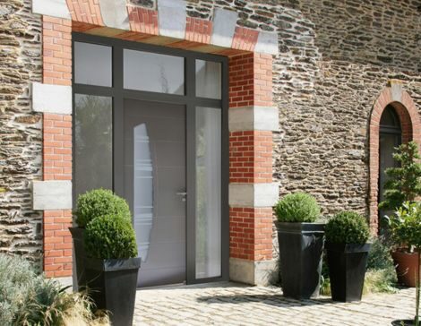 porte d'entrée moderne avec une imposte vitrée et deux fixes vitrés sur une maison en pierre