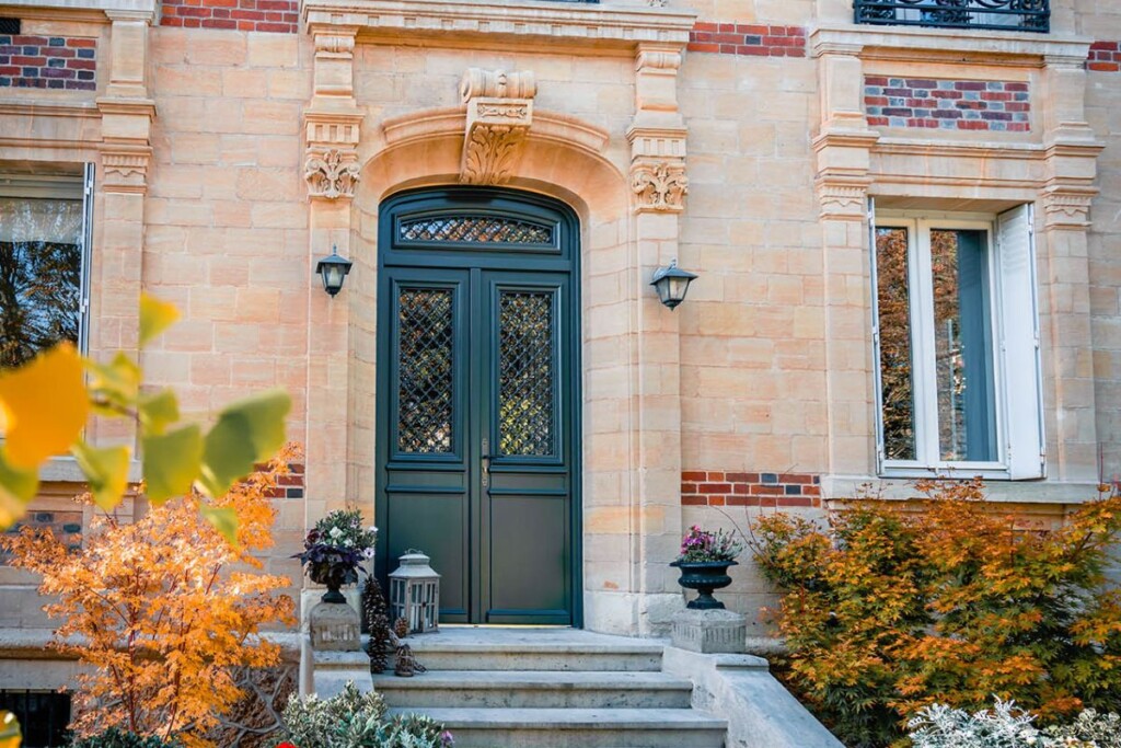 une maison de maître en pierre avec une belle porte d'entrée double vantaux en bois