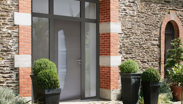 porte d'entrée virgule au style contemporain sur une maison en pierre