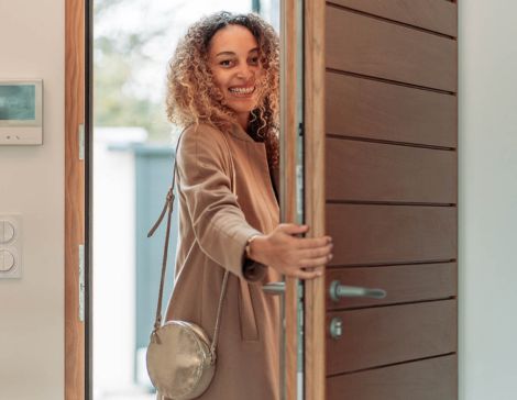 une femme qui ferme une porte d'entrée en bois